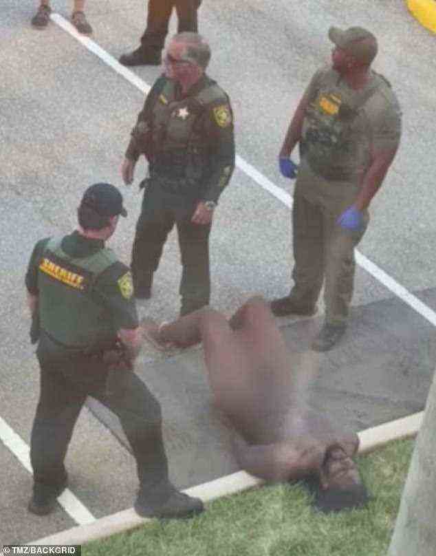 A group of officers stand around the naked McDowell during Monday's arrest in South Florida