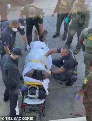 McDowell being placed on a stretcher by police