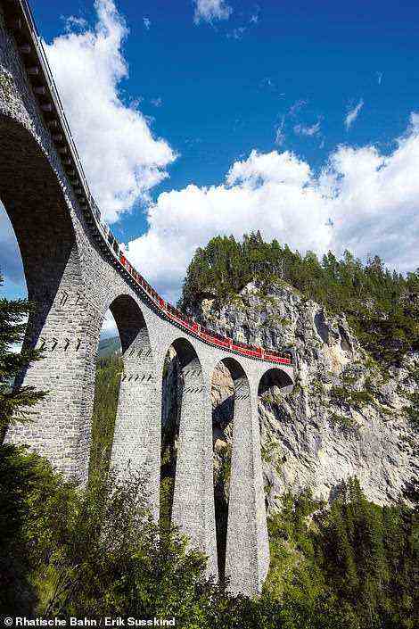 Abgebildet ist der Bernina Express, der auf seinem Weg durch die Schweizer Alpen einen spektakulären Viadukt überquert