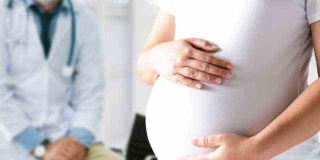 Der Arzt untersucht den schwangeren Bauch für die Gesundheitsuntersuchung des Babys und der Mutter.