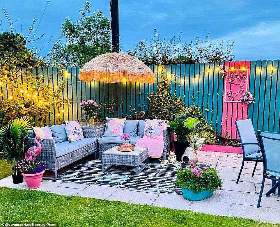 Nach der Renovierung verfügt der Garten über eine Außenbeleuchtung, einen Zaun in leuchtendem Grün und Rosa, einen Sonnenschirm im Freien und Flamingo-Ornamente
