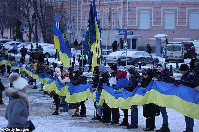 Menschen, die sich zur patriotischen Unterstützung der Ukraine versammeln, halten am Tag der Einheit (22. Januar) ein 500 Meter langes Band in den Farben der ukrainischen Flagge.