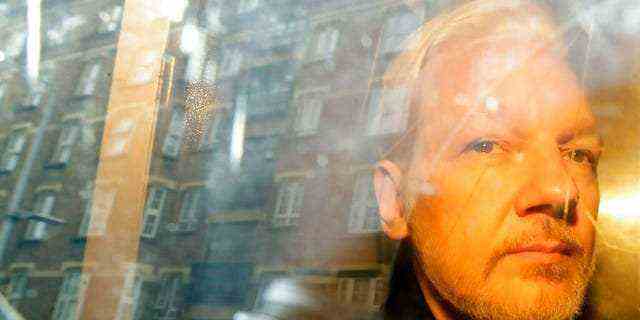 In diesem Archivfoto vom Mittwoch, dem 1. Mai 2019, spiegeln sich Gebäude im Fenster, als WikiLeaks-Gründer Julian Assange in London vor Gericht gebracht wird, wo er vor sieben Jahren unter dem Vorwurf erschienen war, die britische Kaution hintergangen zu haben.  (AP Foto/Matt Dunham)