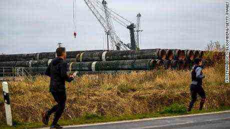Läufer passieren Rohre für die Gaspipeline Nord Stream 2 am Hafen Mukran in Sassnitz, Deutschland.