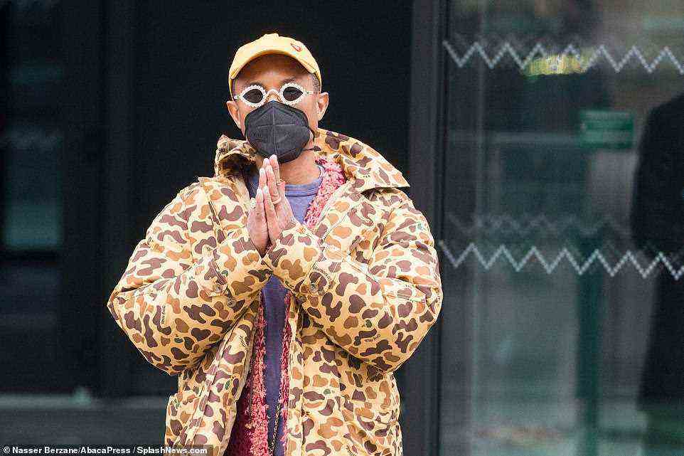 Style: Pharrell also wrapped up for the day in a yellow coat with a brown and gold patterned print