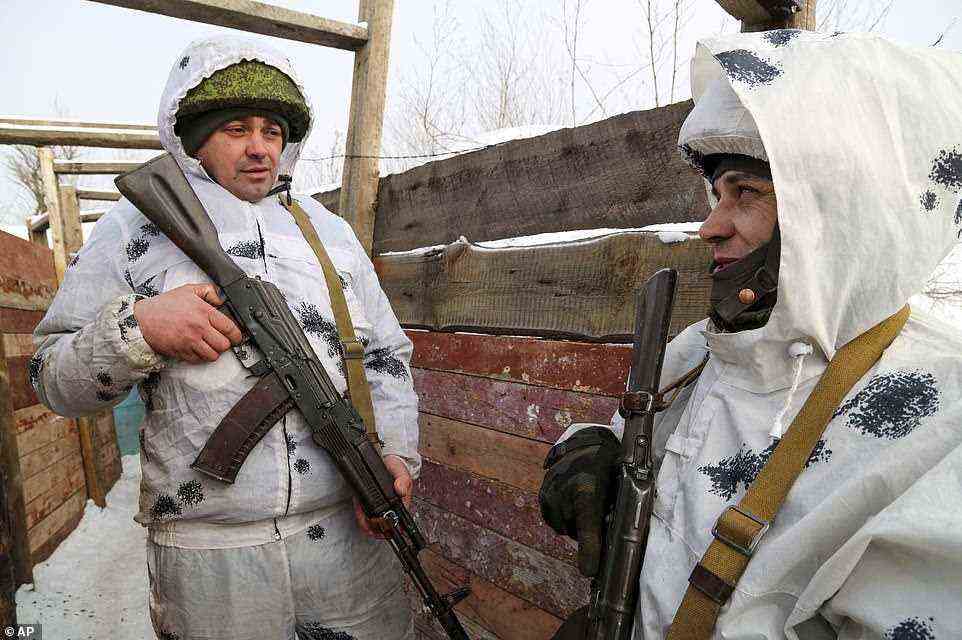 Mosco-backed rebel troops armed with Kalashnikov rifles stand guard in a trench near the frontlines with Ukraine