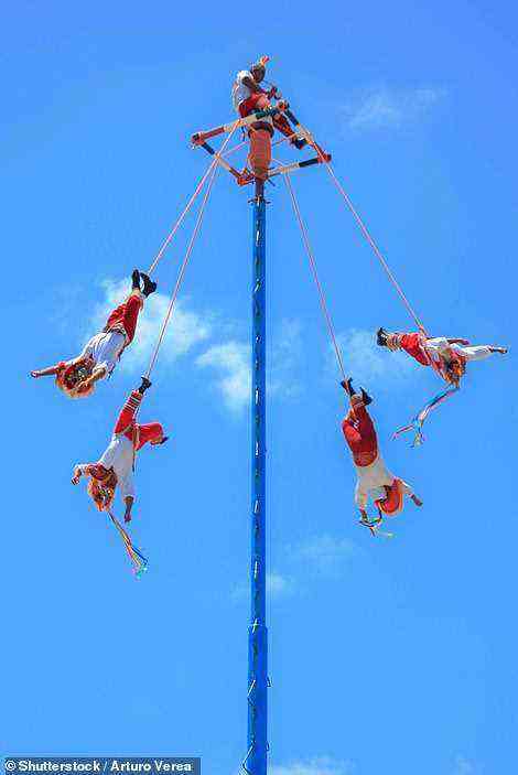 Los Voladores de Papantla führen einen Tanz auf einer Stange auf, während sie „wie Bungee-Jumper an Seilen hängen“ (Stockfoto)