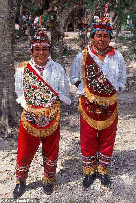 Abgebildet sind zwei Einheimische in der farbenfrohen, traditionellen Kleidung der Region (Stockfoto)