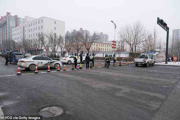 Xiong'an went into lockdown without any official announcements. It is understood authorities set up roadblocks and told residents to return home. Pictured: Policemen control traffic at Anxin County after new Covid-19 cases were reported in Xiong'an New Area