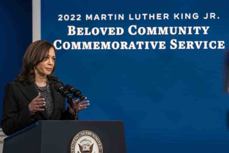 Eine Frau steht auf einem Podium vor einem Bildschirm und verkündet "2022 Martin Luther King Jr. Gedenkgottesdienst der geliebten Gemeinde".