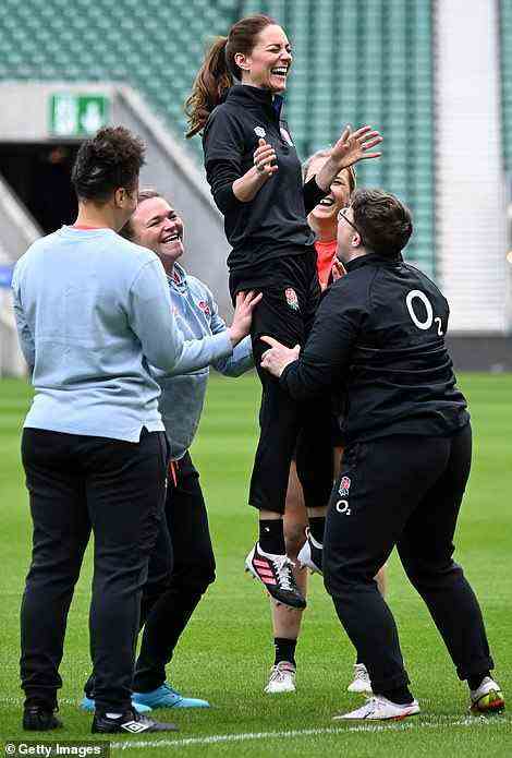 Lifting the spirits! A jovial Kate Middleton giggled as she was hoisted into the air as part of a line-out