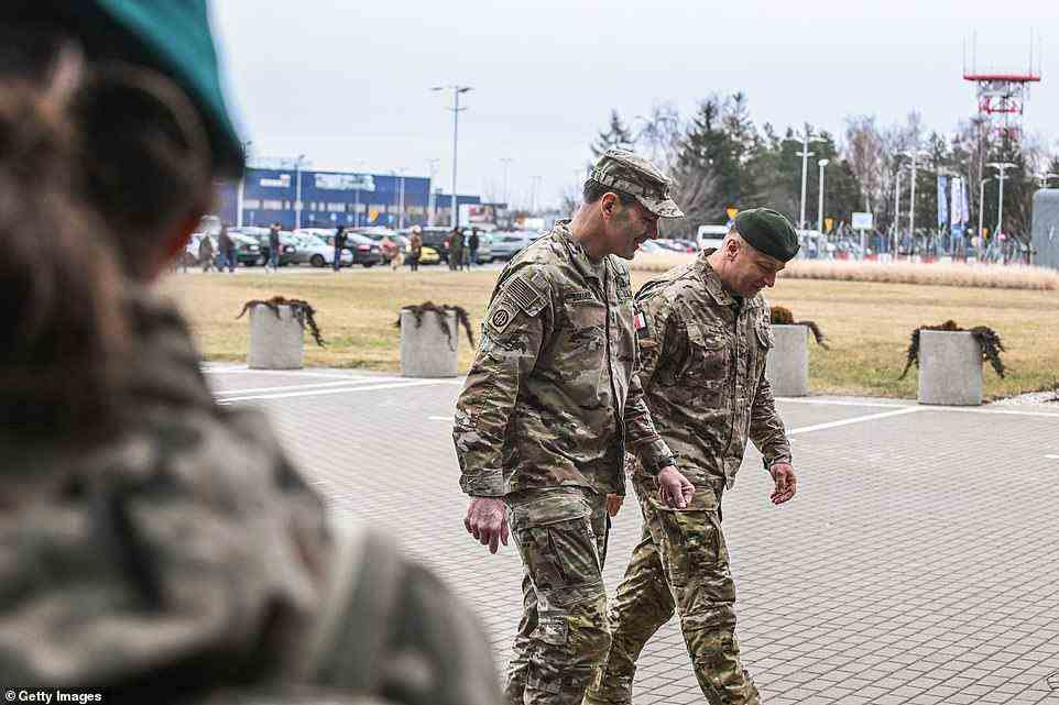 General Donahue (left) and Polish Army General Wojciech Marchwica (right) walk and talk after a press briefing on the arrival of 82nd paratroopers and equipment following unloading of vehicles from the transport plane