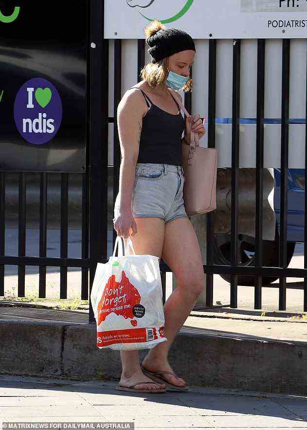 Im Bild: Ein Käufer aus Sydney zieht eine Gesichtsmaske an, nachdem er aus dem Supermarkt zurückgekehrt ist