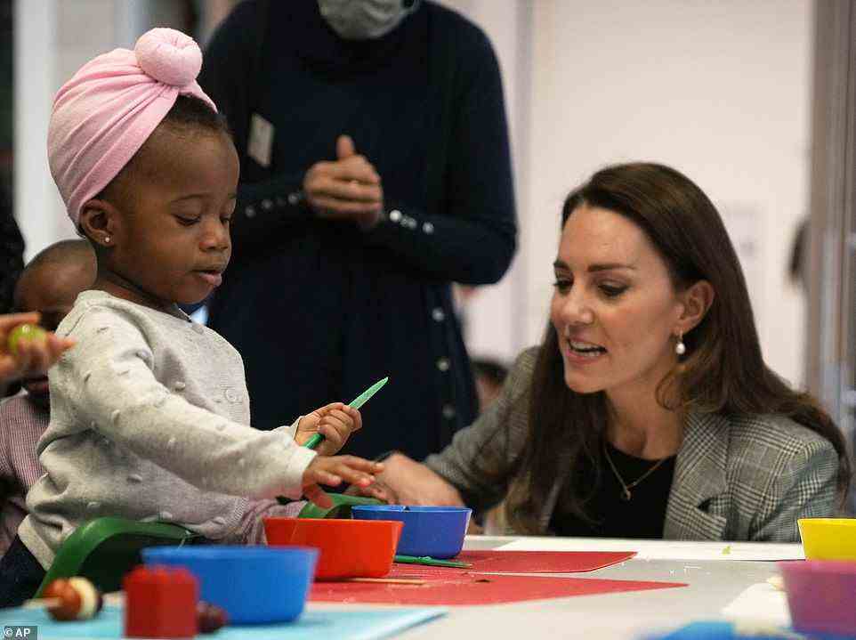 Helping hand: The Duchess of Cambridge interacts with a child named Joy during a cooking workshop at PACT in Southwark, London