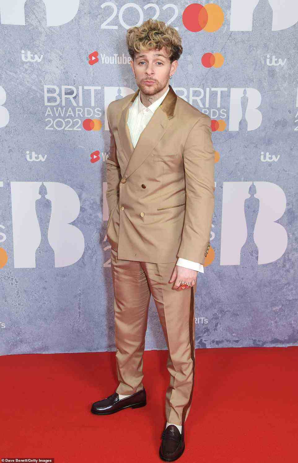 Pout: Tom Grennan showed off his unique sense of style in a cream suit which he teamed with a white shirt and brown shiny shoes