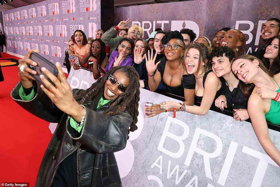 Friendly: Little Simz snapped selfies with her adoring fans as she made her way along the red carpet