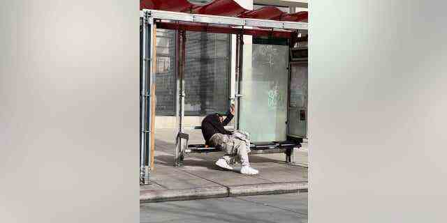 Ein Obdachloser sitzt an einem Bushäuschen in San Francisco im Tenderloin District 