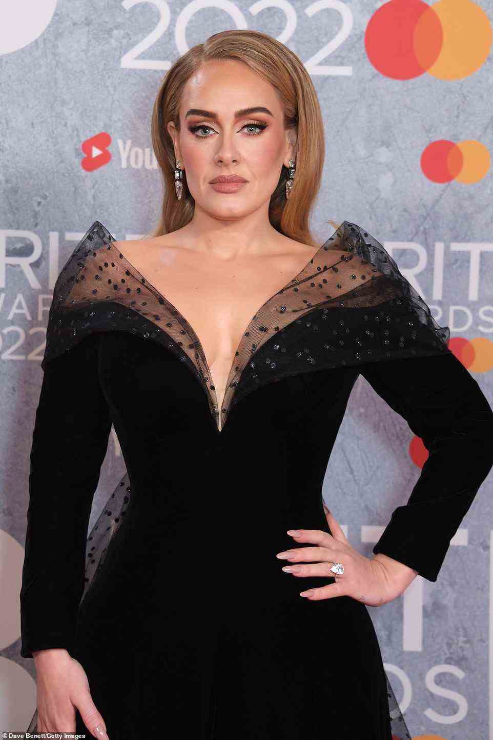 Glowing: Adele wore her hair perfectly blow dried in a sleek style and opted for a typically glamorous makeup look