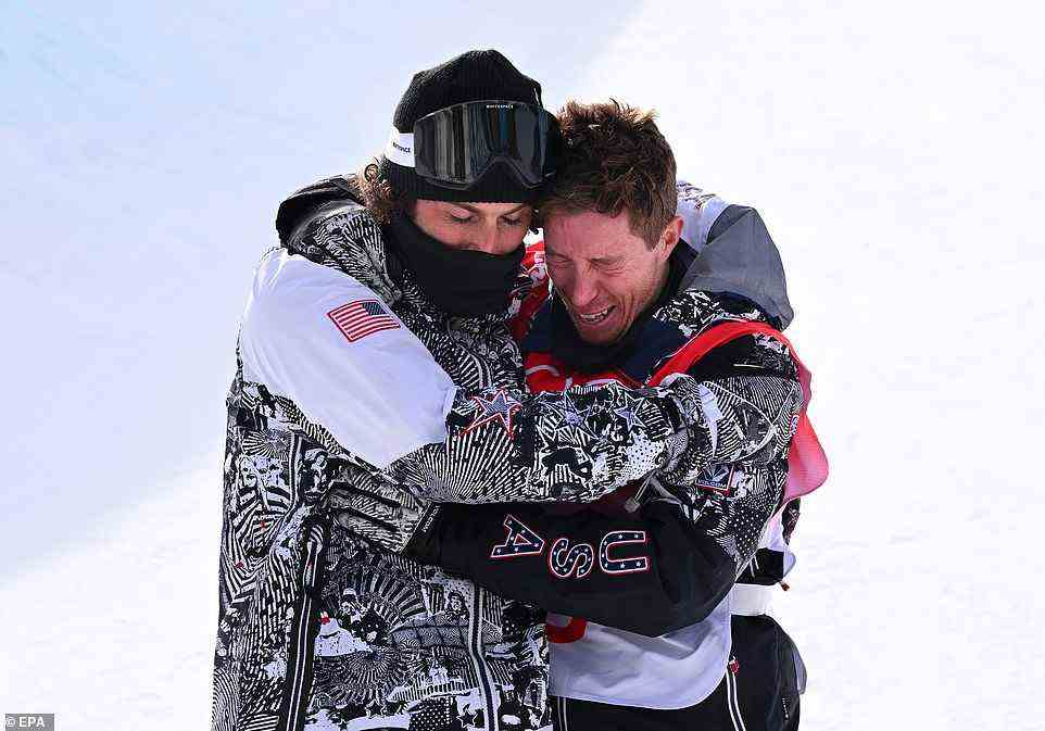 Shaun White of USA reacts as he is hugged by coach JJ Thomas (left) after competing in his last event before retirement