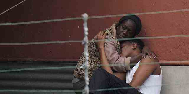 Einwohner umarmen sich nach tödlichen Schlammlawinen in Petropolis, Brasilien, am frühen Mittwoch, 16. Februar 2022.