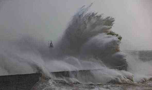 Sturmwellen treffen auf den Wellenbrecher und den Leuchtturm von Newhaven