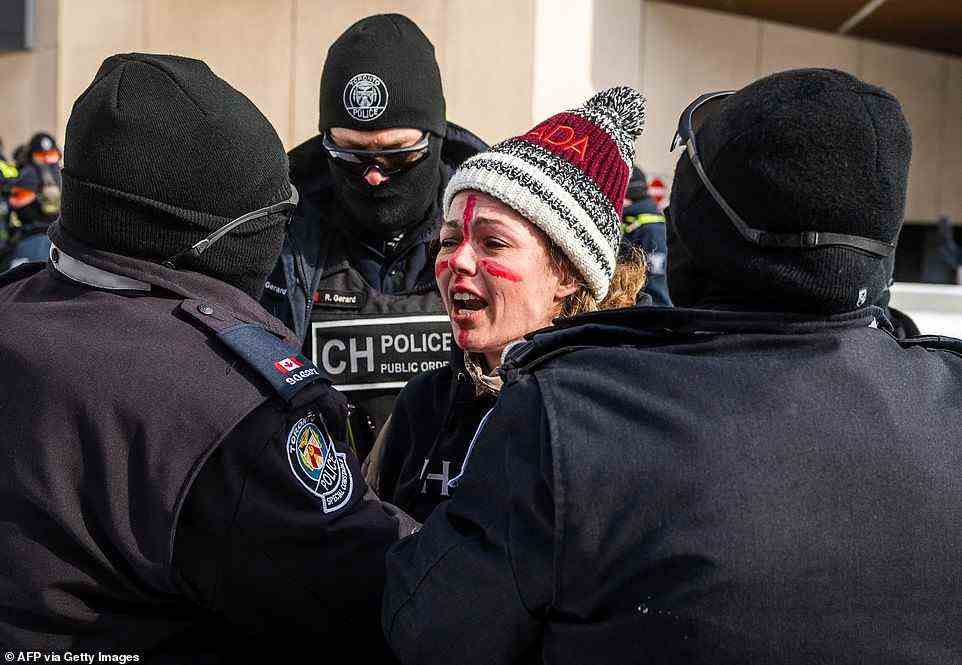 Police arrest a demonstrator participating in the Freedom Convoy in Ottawa on Friday