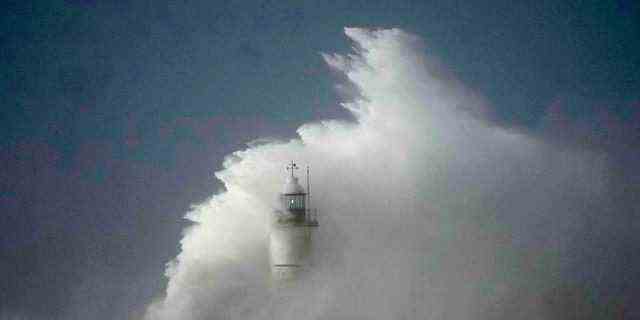 Wellen schlagen über den Wellenbrecher und den Leuchtturm im Hafen von Newhaven, als Sturm Eunice am Freitag, den 18. Februar 2022, auf Newhaven an der Südküste Englands trifft.