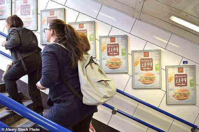 Herr Khan verhinderte vor drei Jahren, dass Lebensmittel und Getränke mit hohem Fett-, Salz- und Zuckergehalt in der U-Bahn, im Schienennetz und an den Bushaltestellen von Transport for London beworben wurden.  Im Bild: People-Walking-Werbung für McDonalds-Burger in der U-Bahnstation Oxford Circus, bevor das Verbot eingeführt wurde
