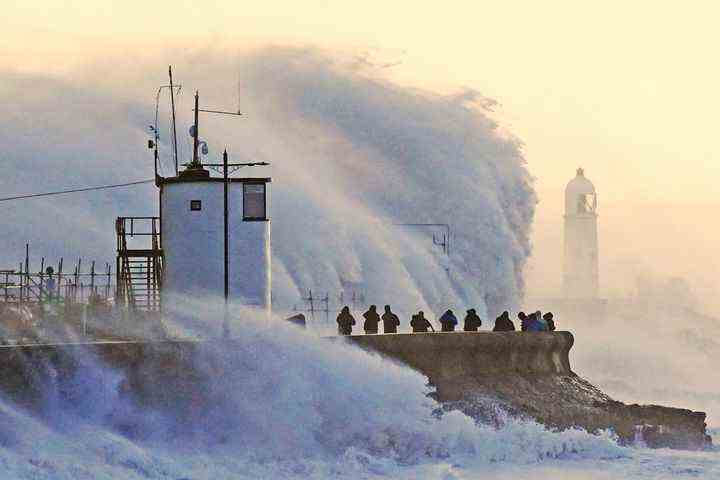 Wellen schlagen gegen die Ufermauer und den Leuchtturm von Porthcawl in Porthcawl, Bridgend, Wales, Großbritannien, als Sturm Eunice am Freitag, den 18. Februar 2022, auf Land trifft. 