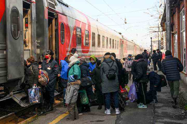 Menschen aus Donezk, dem von einer pro-russischen Separatistenregierung kontrollierten Gebiet in der Ostukraine, stehen Schlange, um einen Zug nach Russland zu bekommen, nachdem sie am Sonntag in der Region Rostow am Don nahe der Grenze zur Ukraine evakuiert wurden.