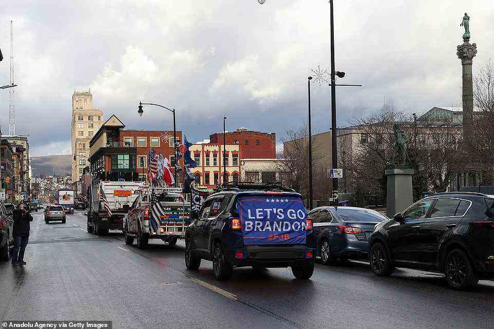 A truck convoy headed to DC from Pennsylvania is pictured leaving Scranton on Wednesday. The drivers have decorated their vehicles to sport American flags and protest messages including the anti-Biden slogan 'Let's Go Brandon'
