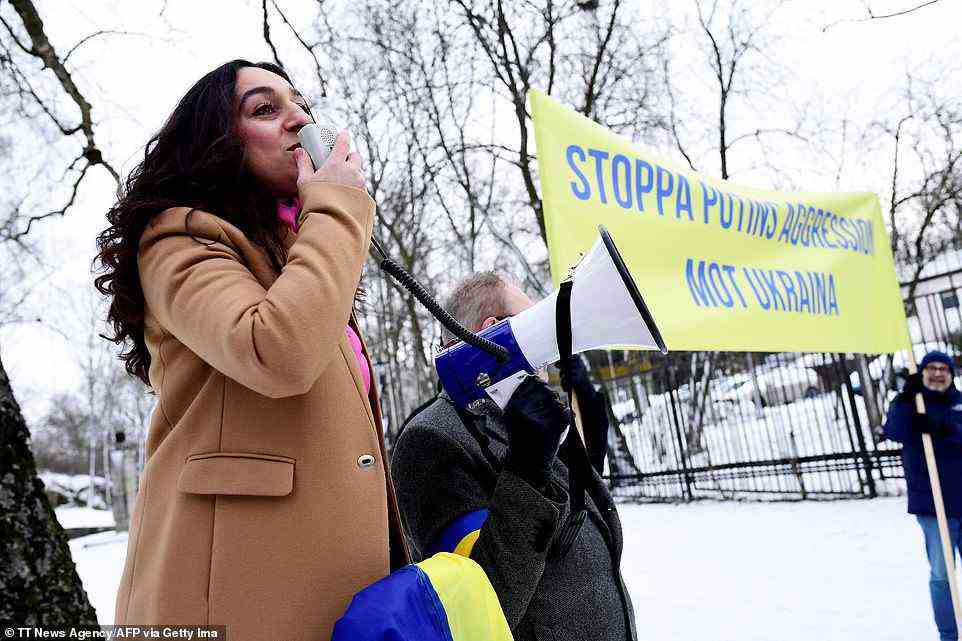Lusine Djanyan, from protest group Pussy Riot, stands next to demonstrators in Stockholm holding a placard reading 'Stop Putin's aggressions against Ukraine'
