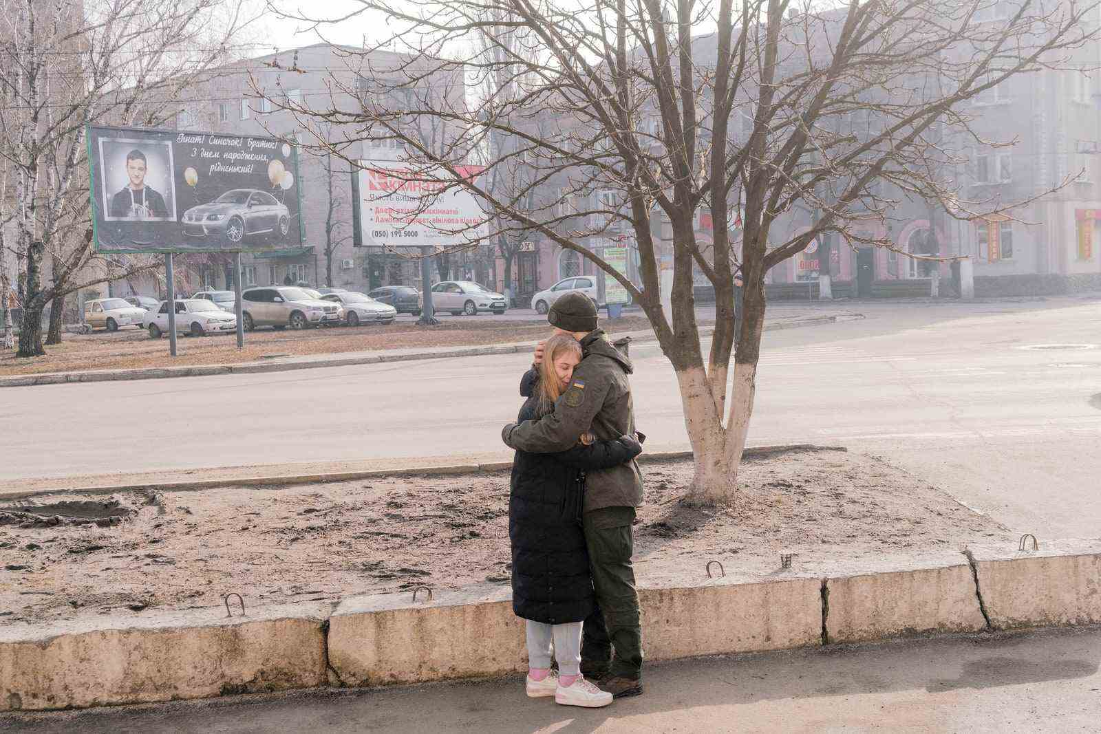 UKRAINE Slowjansk.  24. Februar 2022 Ein Mitglied der ukrainischen Nationalgarde umarmt einen geliebten Menschen in der Nähe einer Militärbasis in...