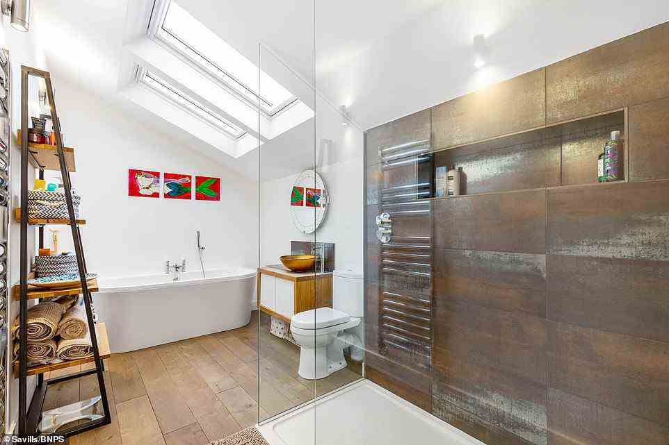 Das Badezimmer des Anwesens verfügt über eine große begehbare Dusche und eine riesige Badewanne, die sich perfekt zum Entspannen eignet, und die Wände sind mit skurrilen Gemälden geschmückt