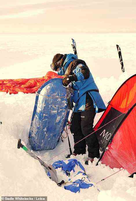 Einer der Teammitglieder gräbt seinen Schlitten aus dem Schnee