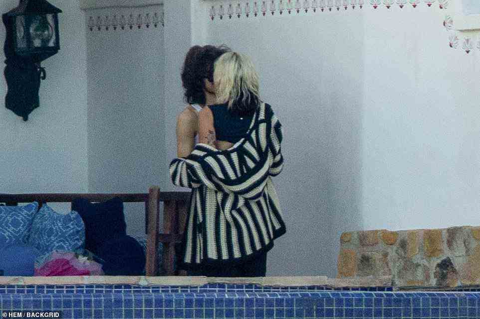 Making out: The Party In The USA singer wrapped her arms around her beau as they kissed on the courtyard attached to their room