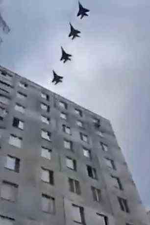 Four fighter jets fly over a city in Ukraine