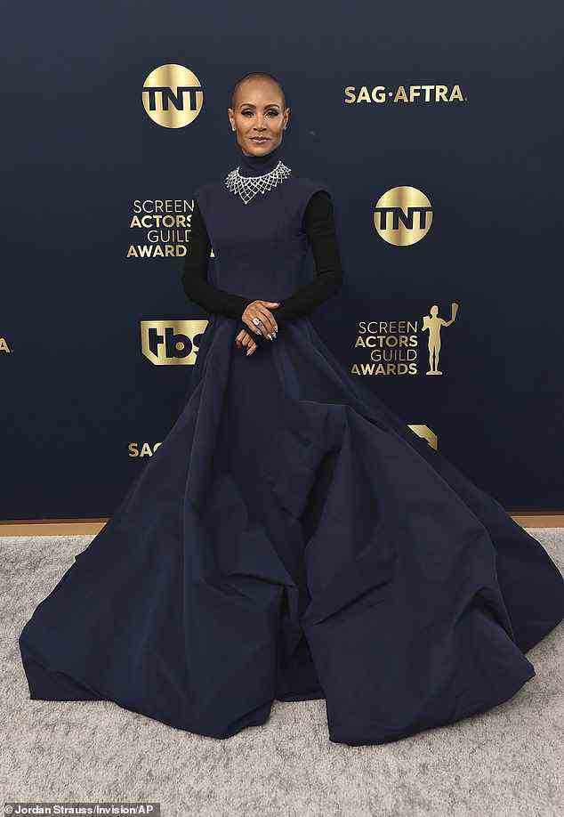 Gorgeous: Jada cut a glamorous figure in an eye-catching navy blue gown with an elegant high neck that flowed into a dramatic skirt, layered over a black knitted polo neck