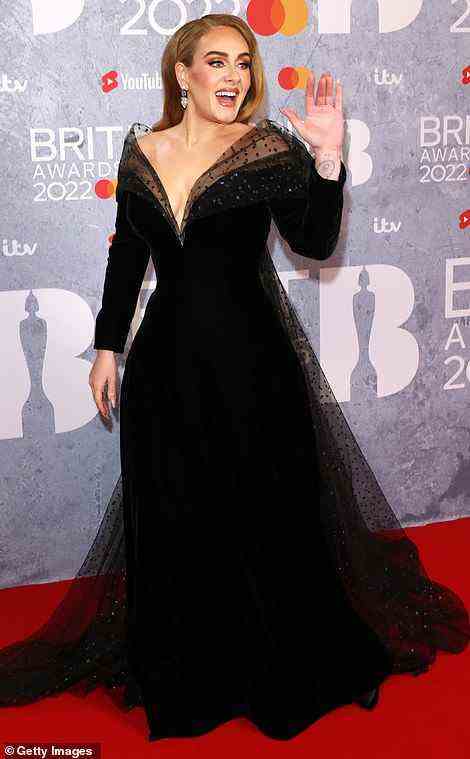 Showstopper: Adele looked resplendent in a sweeping black ballgown with a twinkling sheer black overlay on the red carpet