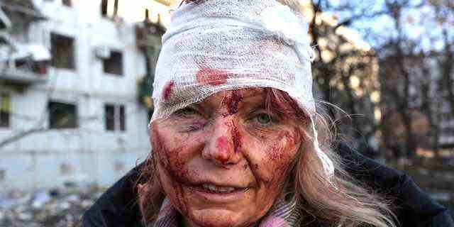 Eine verwundete Frau wird am 24. Februar 2022 gesehen, als ein Luftangriff einen Apartmentkomplex außerhalb von Charkiw, Ukraine, beschädigt.