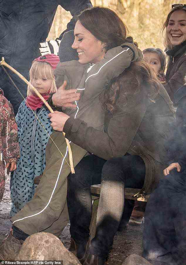 Die Herzogin schloss sich der Waldschulgruppe des Kindergartens am Lagerfeuer an und konnte gesehen werden, wie sie einem Jungen, der einen khakifarbenen Strampler trug, eine riesige Umarmung anbot