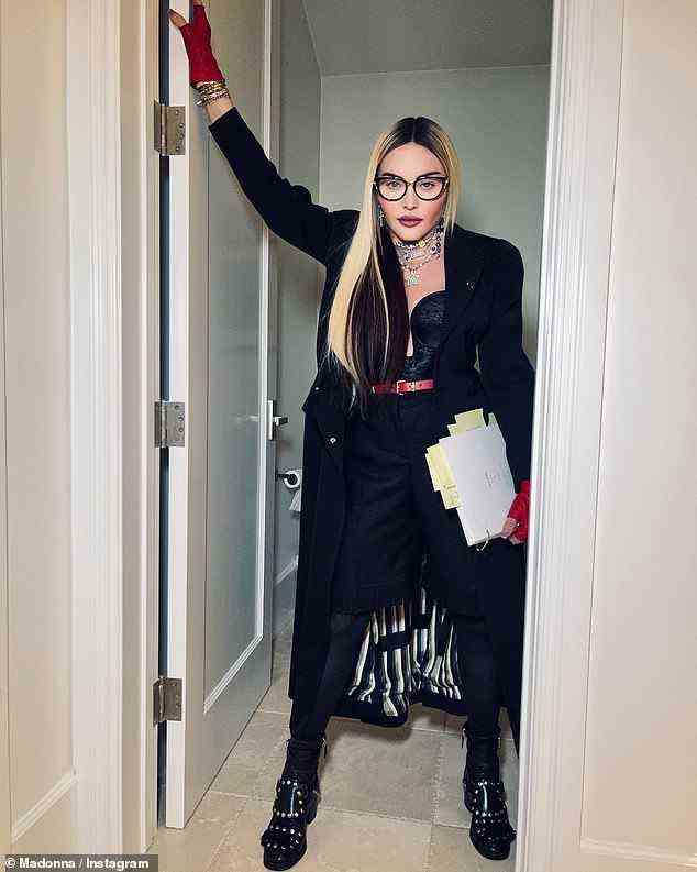 Lesen im Badezimmer: Madonna, 63, sah in einem überwiegend schwarzen Ensemble schick aus, als sie enthüllte, dass ihr bevorstehendes Biopic derzeit den Titel Little Sparrow trägt, während sie das Drehbuch in einem Instagram-Post vom Dienstag im Badezimmer las
