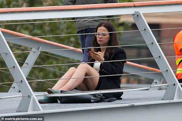 Taking a seat: At one stage, the former Home and Away star decided she needed to rest, sitting on the ground as she checked her phone