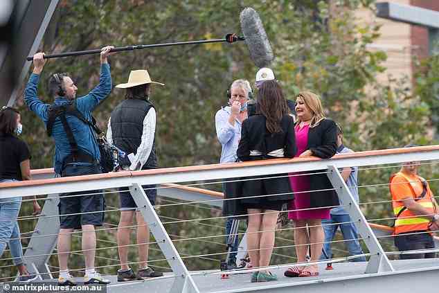 Mic'd up: The two actresses stood alongside each other as they filmed on the bridge, with a boom operator holding a microphone above them