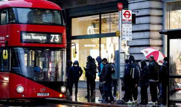Pendler warten vor einem Bus vor der U-Bahnstation Oxford Street