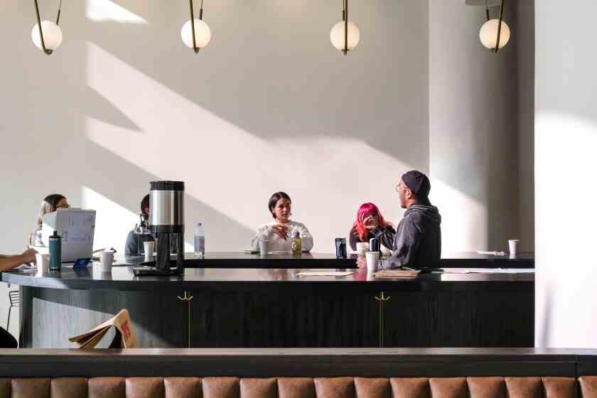 Ein Foto von ein paar Leuten, die an einer minimalistischen Kaffeebar sitzen