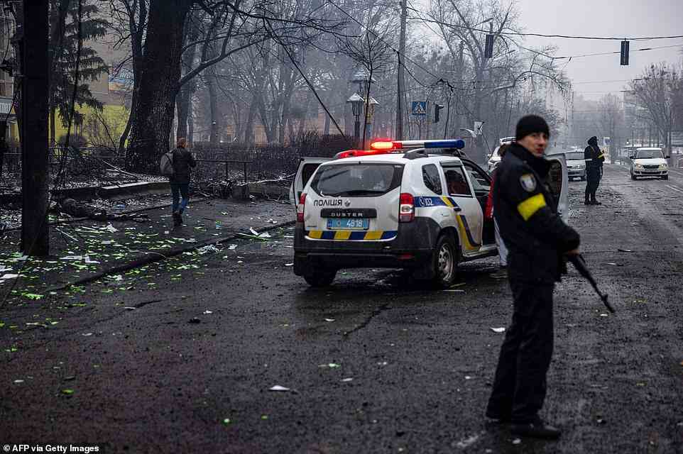 Police officers stand guard at the site of Tuesday's airstrike that hit Kyiv's main television tower