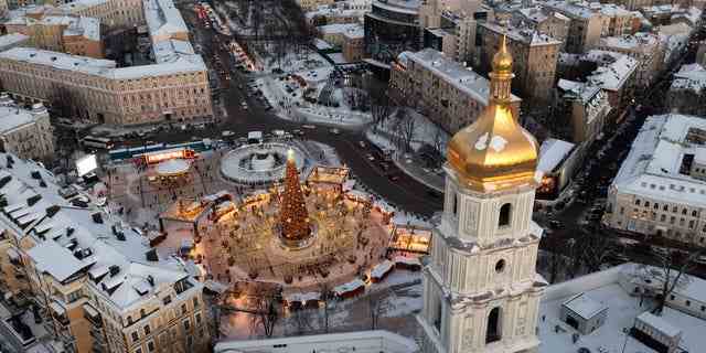 Schnee bedeckt das Stadtzentrum mit einem Weihnachtsbaum, der St.-Sophia-Kathedrale im Vordergrund und der St.-Michael-Kathedrale im Hintergrund in Kiew, Ukraine, Dienstag, 21. Dezember 2021. 
