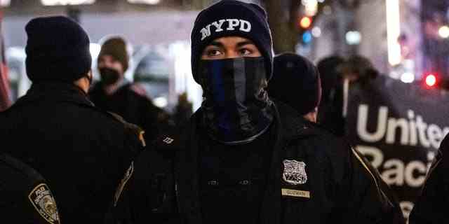 Ein Mitglied der NYPD mit einer „Back the Blue“-Gesichtsmaske steht am 6. Januar 2022 in New York City vor der St. Patrick's Cathedral.