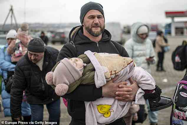 A man with a child in his arms at the Porubne border crossing on Saturday